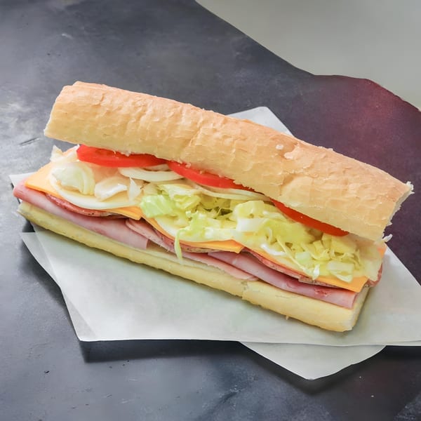 A large Anthony's Pizza sub sandwich with ham, salami, cheese, lettuce, tomatoes, and onions.