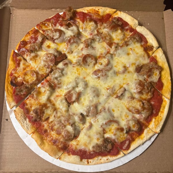 Anthony's Pizza pepperoni and sausage pizza, cut into squares, in a cardboard box.